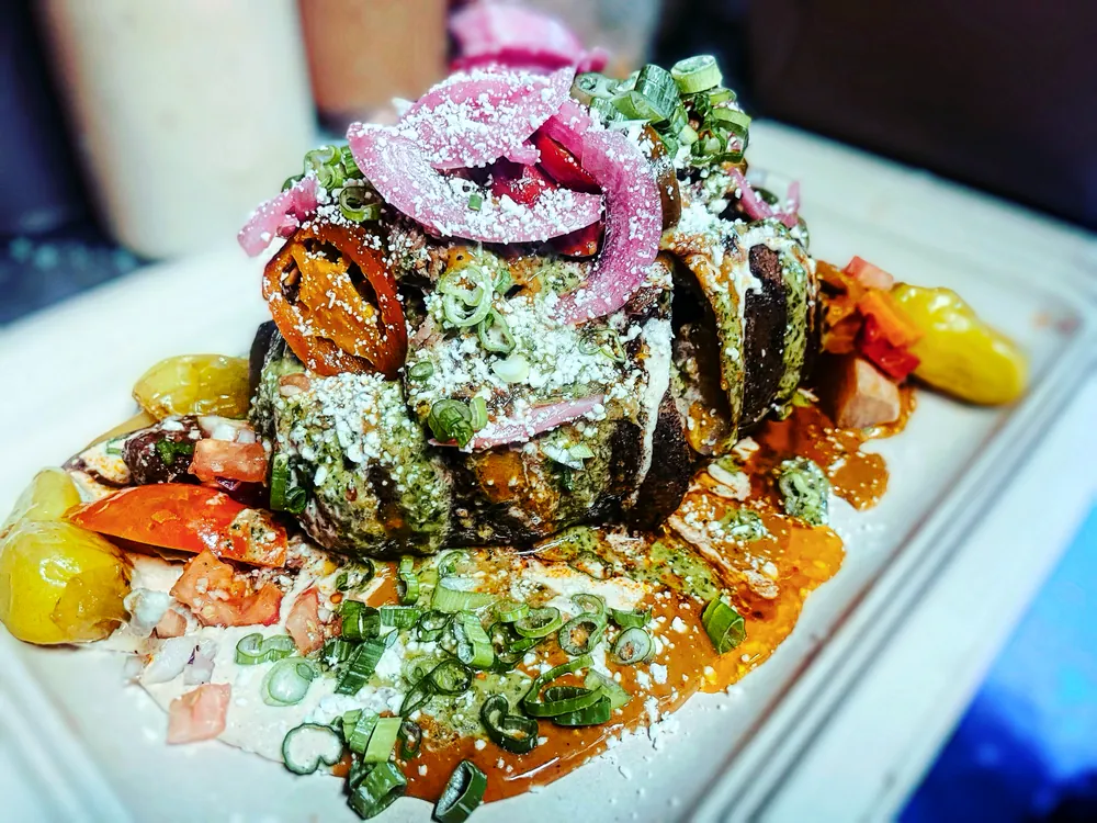 Smoked pork belly bites with pickled onion and herbs