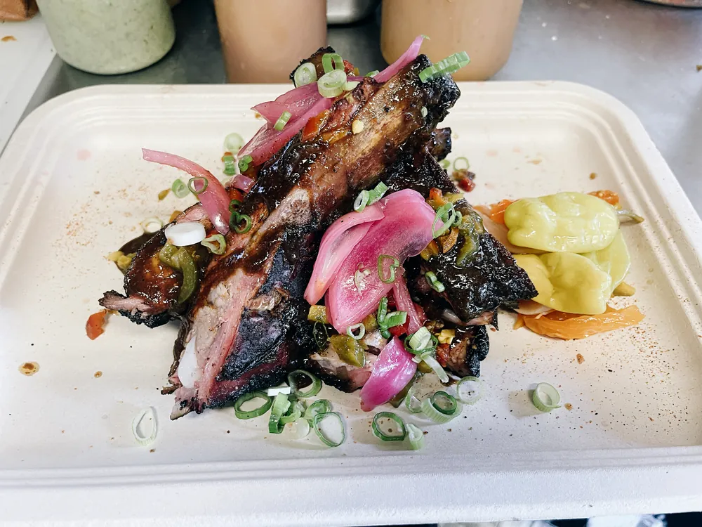 Smoked beef rib plated with pickled onion and peppers